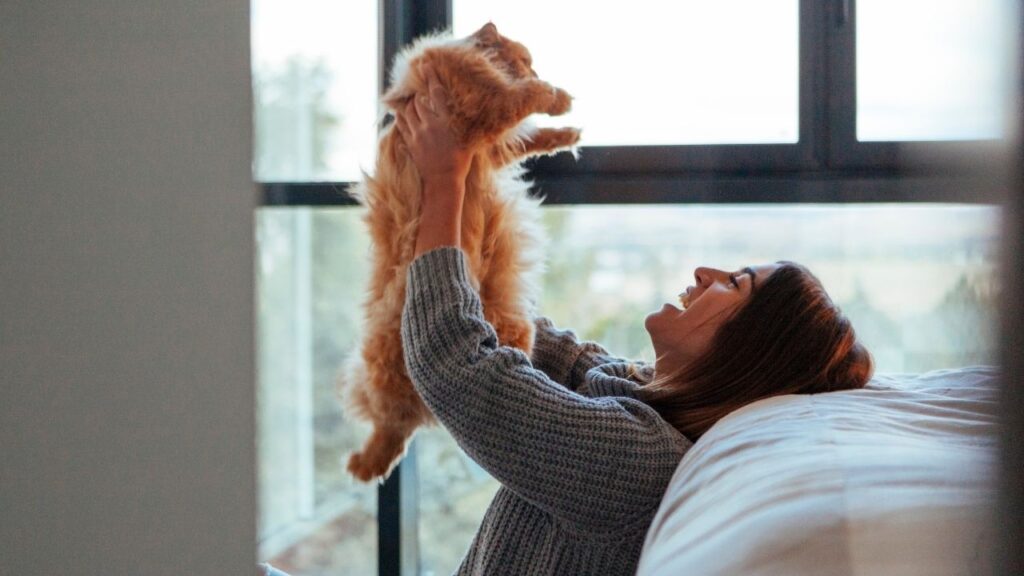 woman with cat in bedroom