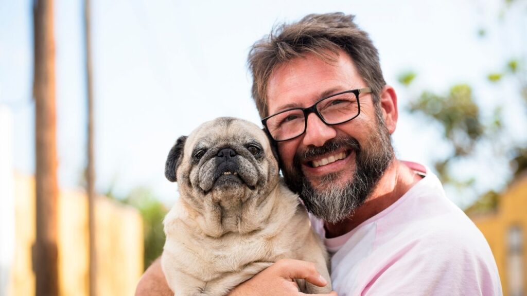 smiling man holding dog