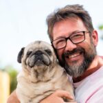 smiling man holding dog