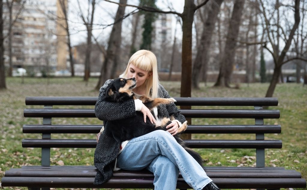 sitting with emotional support dog in park