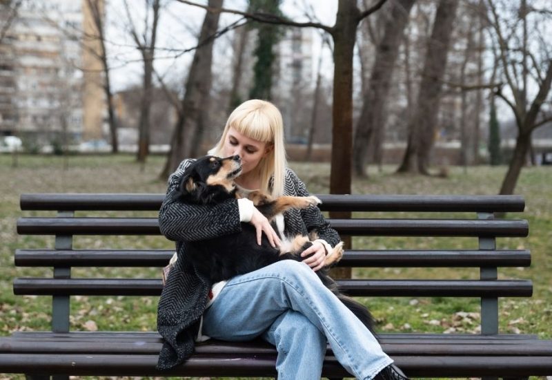 sitting with emotional support dog in park