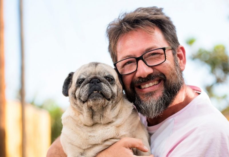 smiling man holding dog